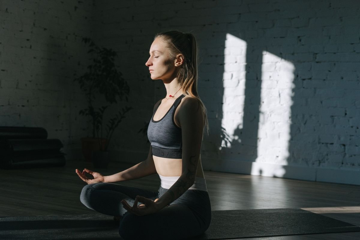 Pessoa em posição meditativa com expressão de receptividade, como se aguardando uma resposta que chegará em seu próprio tempo