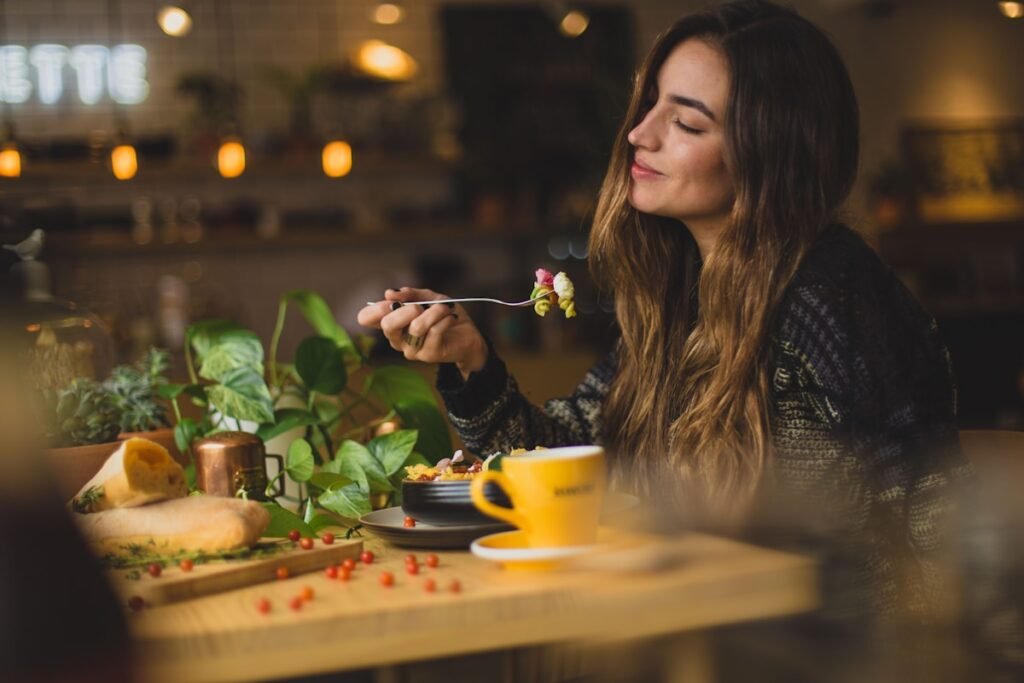 Mulher saboreando a comida de olhos fechados, atenta ao que o corpo pede